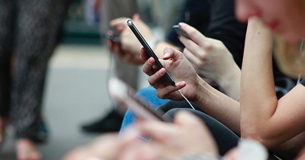 A close up of a group of people using their mobile device.