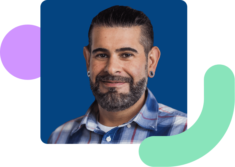 Image shows a man smiling with a dark blue background