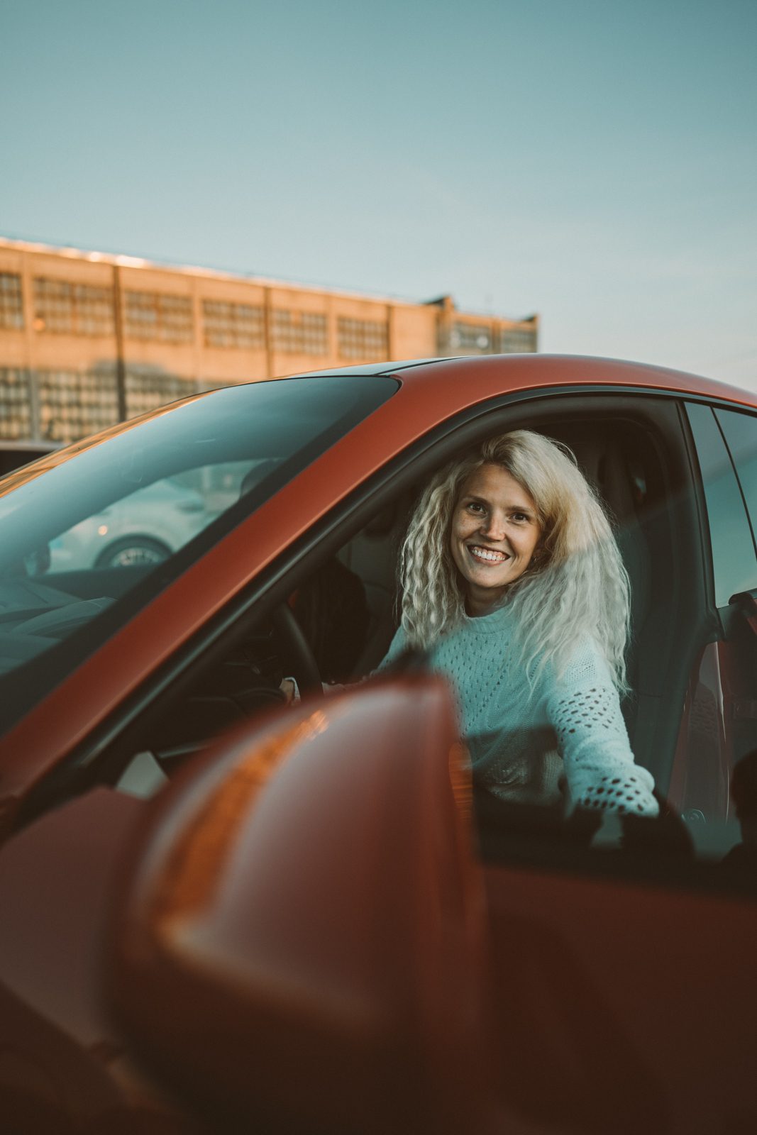 Kristel, the founder of Testlio, sits in a red porsche sports car during her video shoot with them.