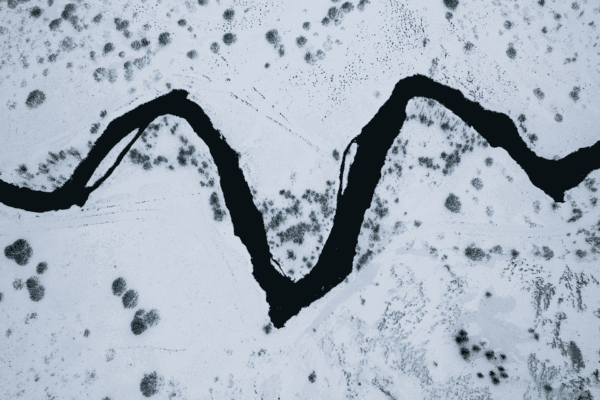 Aerial view of a winding river through a snowy landscape
