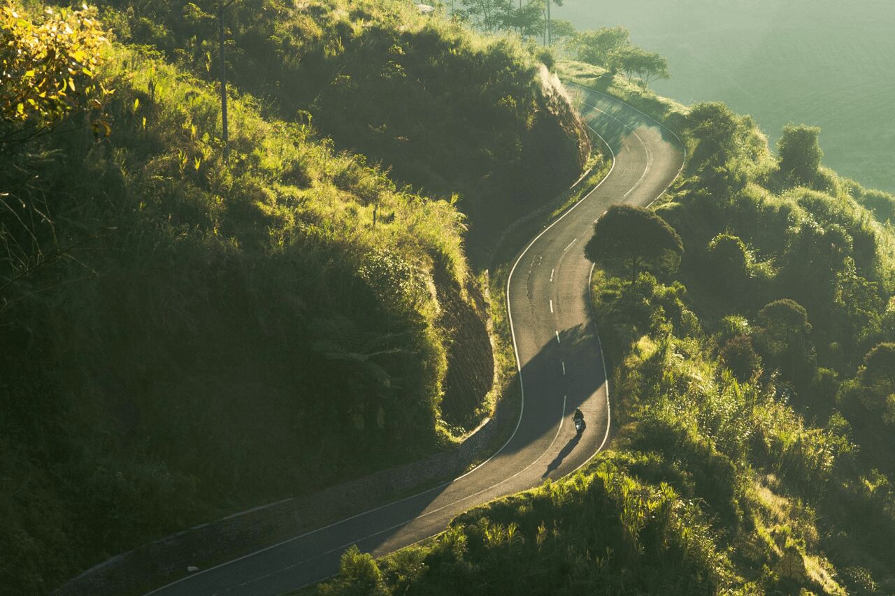Narrow, winding road on a green mountain